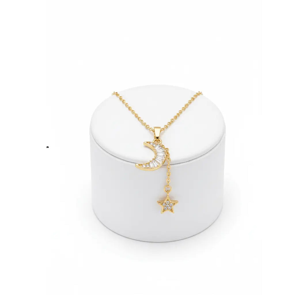 Gold Moon & Star Celestial Necklace with moon and star pendant on a white stand