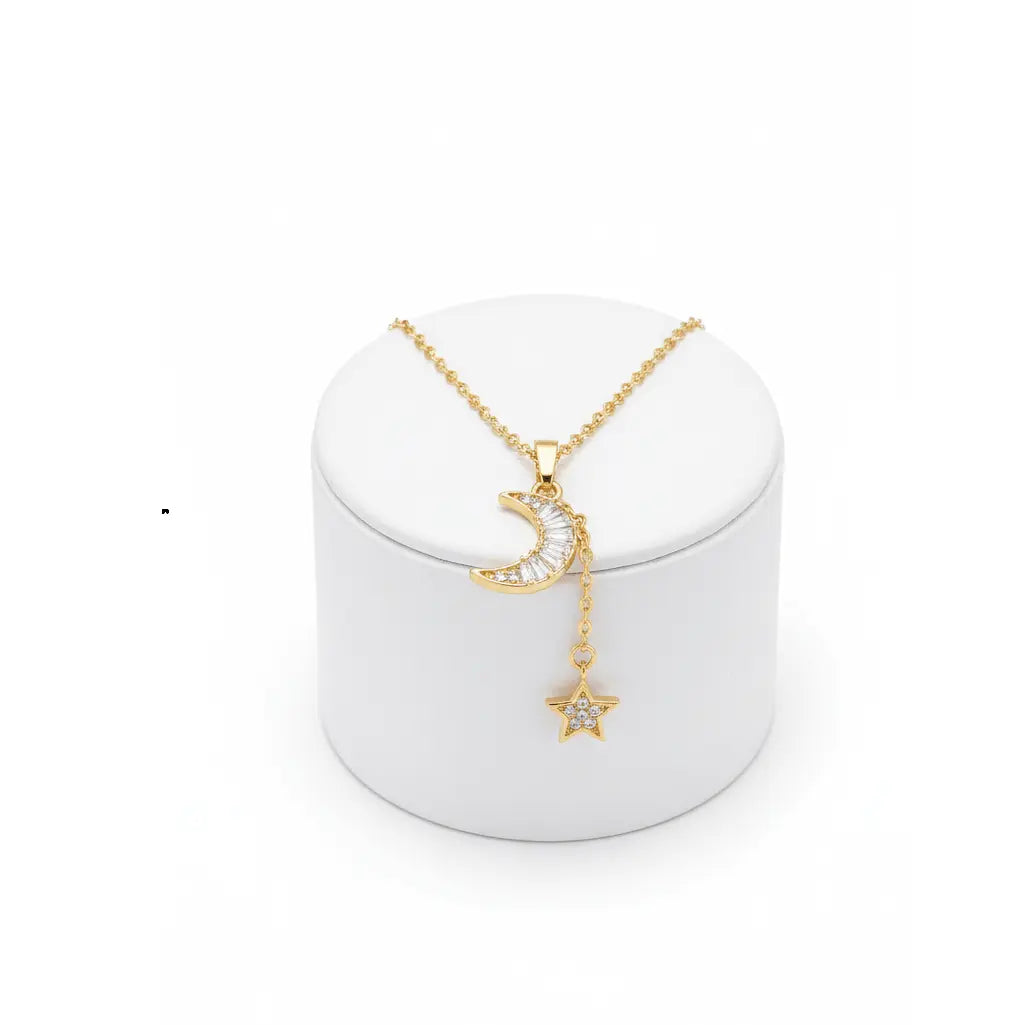 Gold Moon & Star Celestial Necklace with moon and star pendant on a white stand