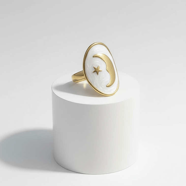 Gold Moon and Star Oval Ring on a white podium with a polished gold-tone frame and celestial design.
