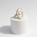Gold Moon and Star Oval Ring on a white podium with a polished gold-tone frame and celestial design.