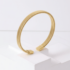 Gold Ribbed Coil Bangle Bracelet on pedestal in standing angel