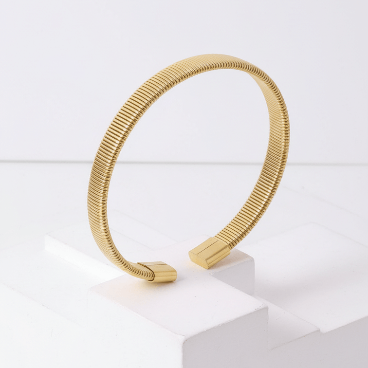 Gold Ribbed Coil Bangle Bracelet on pedestal in standing angel