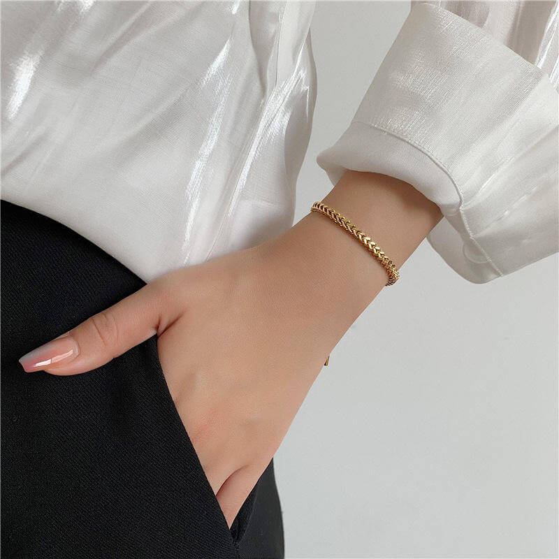 Gold Rope Chain Adjustable Bracelet on a wrist with a white shirt and black pants against a light gray background