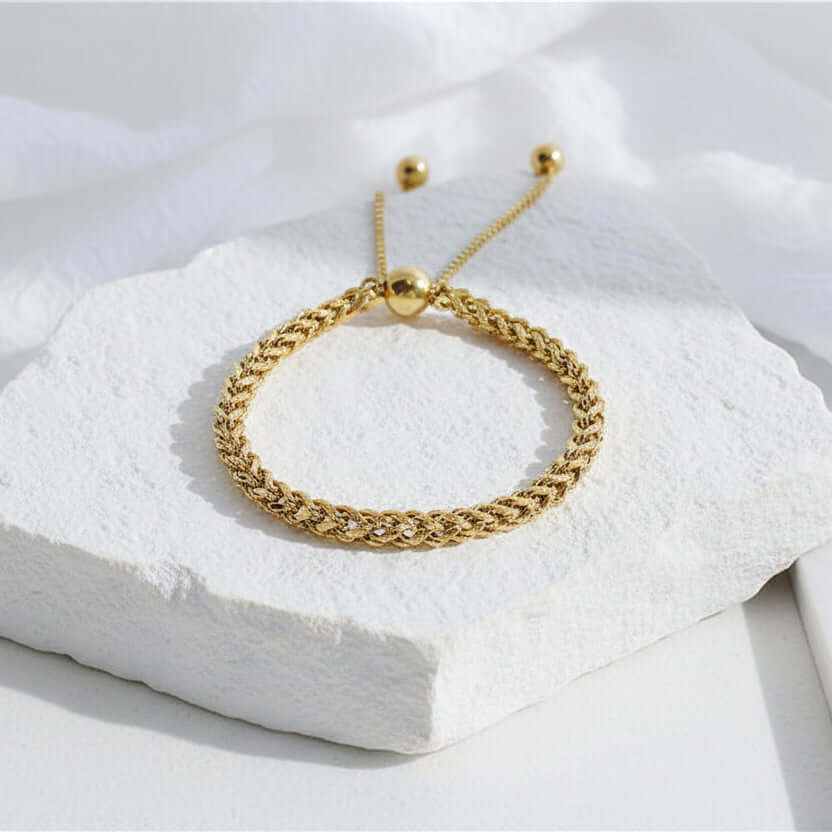 Gold Rope Chain Adjustable Bracelet on a white stone 