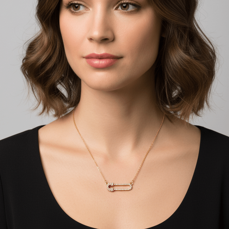 Woman wearing a Gold Safety Pin Pendant Necklace against a neutral background
