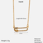 Gold Safety Pin Pendant Necklace with Ceyrah branding, showing measurements and features on a white background.