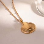 Gold Scallop Shell Pendant Necklace layering on floor