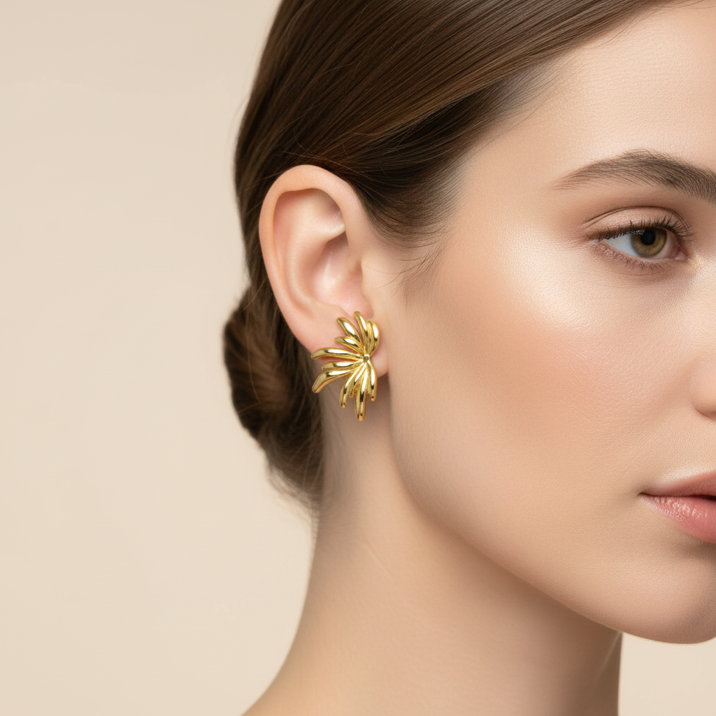 A close-up of a woman's ear wearing a Gold Sculpted Petal Stud Earrings against a soft beige background.