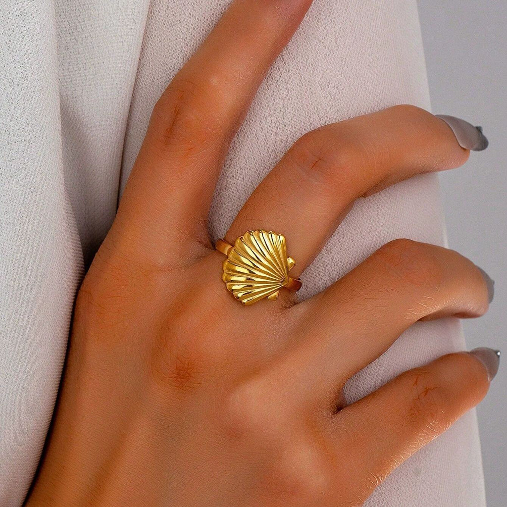 Gold Seashell Adjustable Ring worn on a hand, showcasing its sculpted seashell design and radiant gold finish.