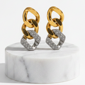 Gold & Silver Pavé Chain Link Earrings displayed on a round white marble pedestal against a clean white background.