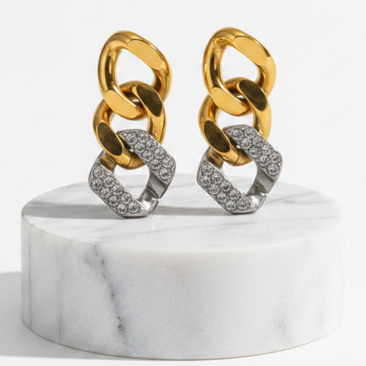 Gold & Silver Pavé Chain Link Earrings displayed on a round white marble pedestal against a clean white background.