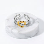 Gold & Silver Heart Adjustable Ring with a textured gold heart-shaped accent in the center, shown with printed dimensions and weight on a white background.