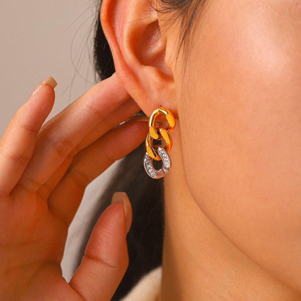 A close-up of a person's ear wearing Gold & Silver Pavé Chain Link Earrings against a soft neutral background.
