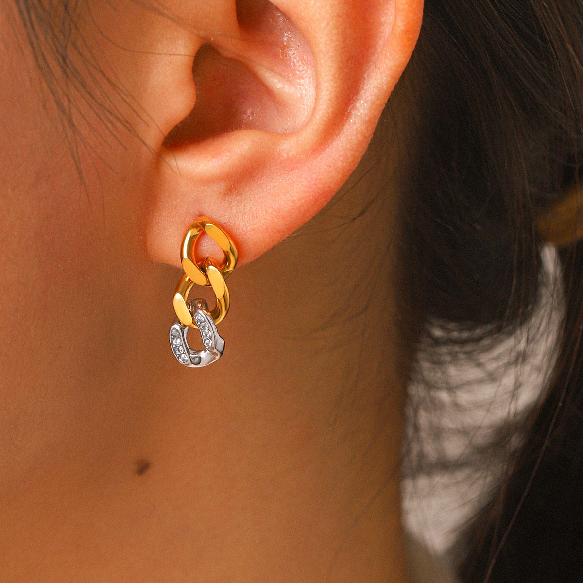 A close-up of a person's ear wearing Gold & Silver Pavé Chain Link Earrings