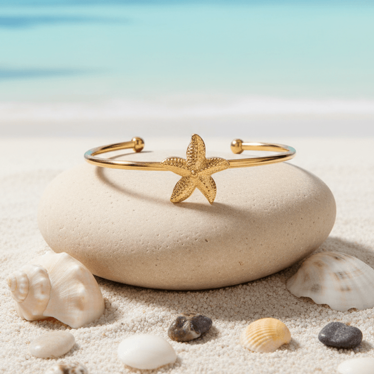 Gold Starfish Bangle Bracelet on stone beach background