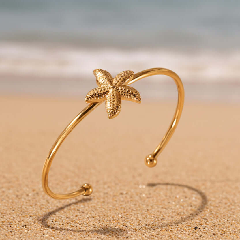 Gold Starfish Bangle Bracelet on beach 