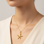 Gold starfish necklace on a mannequin with a plain background