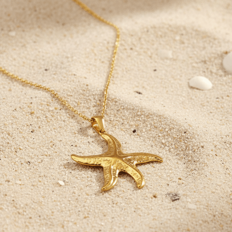 Gold Starfish Pendant Necklace on a sandy surface