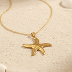 Gold Starfish Pendant Necklace on a sandy background