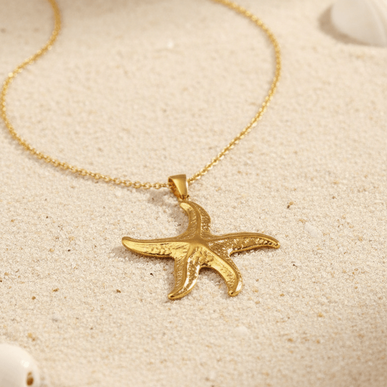 Gold Starfish Pendant Necklace on a sandy background