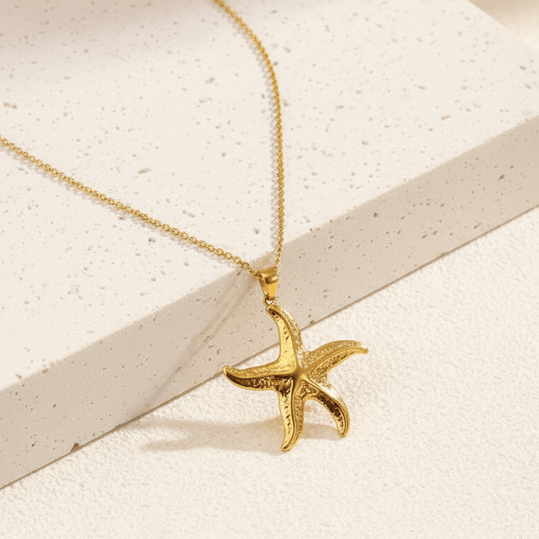 Gold starfish pendant necklace on a neutral background