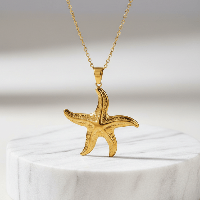 Gold Starfish Pendant Necklace on a white marble base