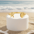 Gold bracelet on a white cylindrical stand with a beach background