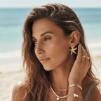 Woman on a beach wearing Gold_Starfish_Stud_Earrings with a blurred background