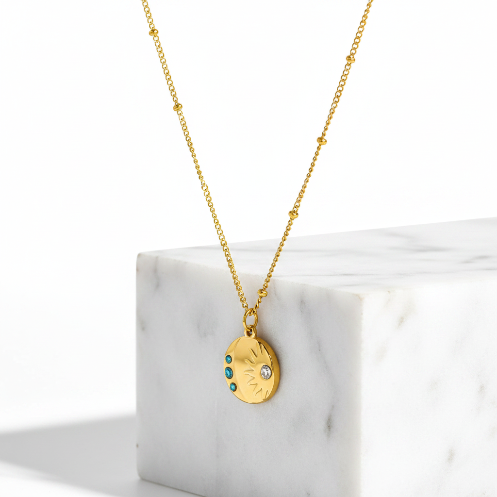 A Gold Sunburst Gemstone Necklace displayed on a white marble block against a white background.