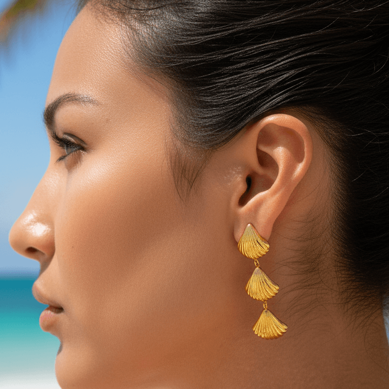 Woman wearing gold earrings with a beach background