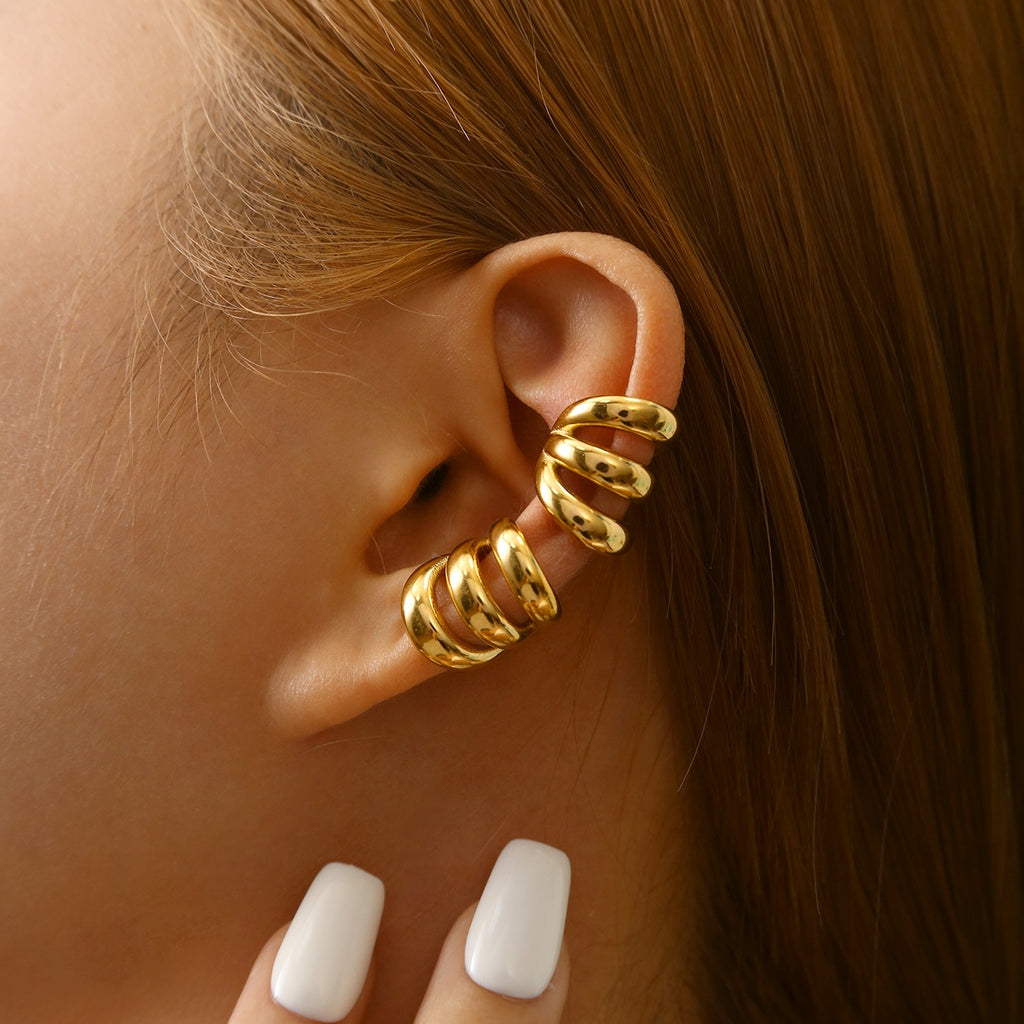 Gold Triple Band Ear Cuff worn by a person with white nail polish.
