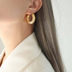 Close-up of a woman wearing a gold Gold Twisted Hoop Earrings - Ceyrah jewellery