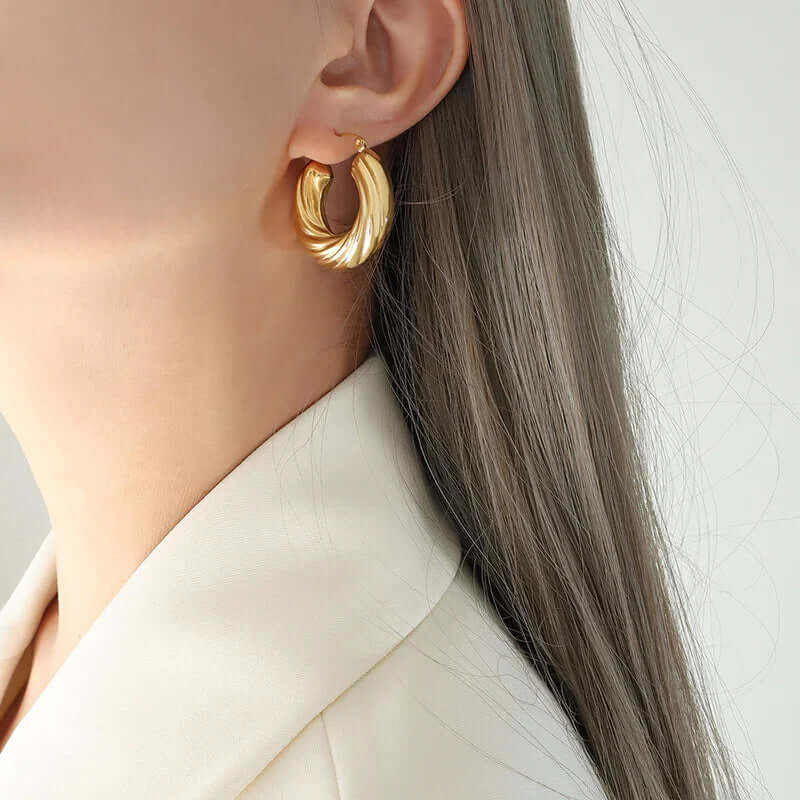 Close-up of a woman wearing a gold Gold Twisted Hoop Earrings - Ceyrah jewellery