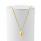 Gold Water Drop Necklace with a teardrop pendant on a white stand