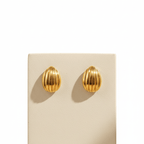 Pair of  Gold Ribbed Teardrop Stud Earrings on a beige card against a beige background