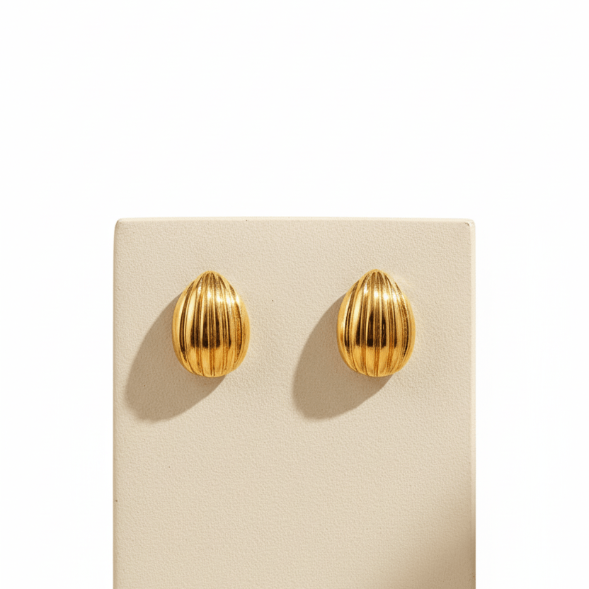 Pair of  Gold Ribbed Teardrop Stud Earrings on a beige card against a beige background