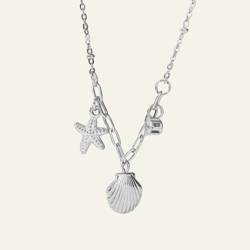 Ceyrah silver necklace with starfish, seashell, and letter charms on delicate chain