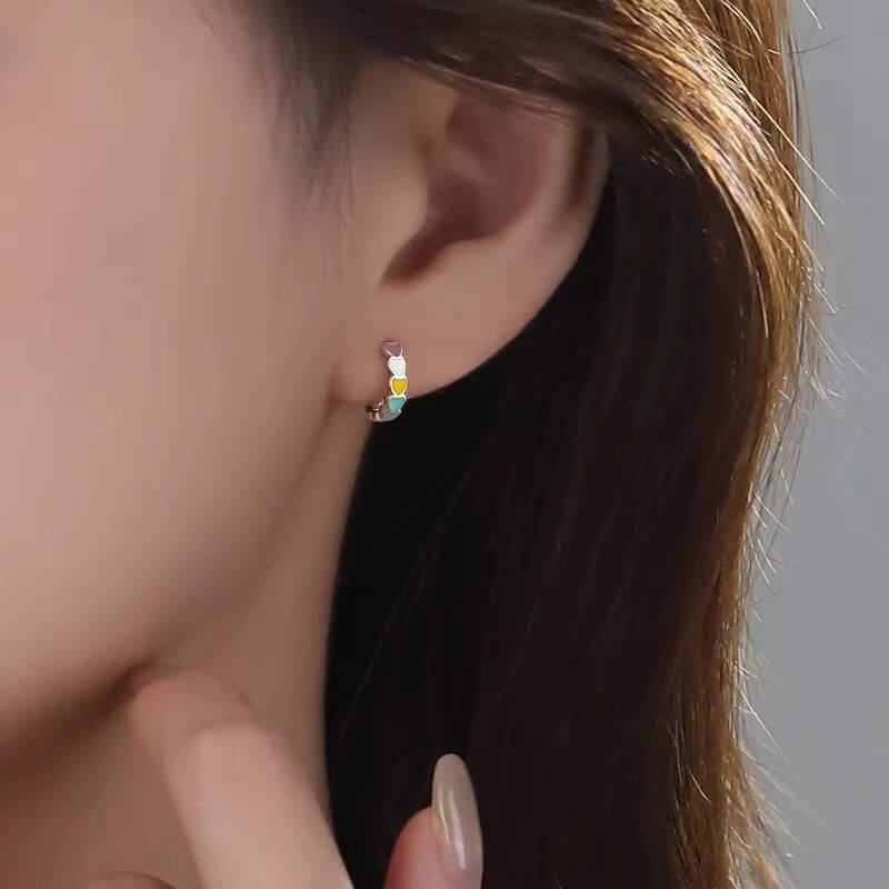 Close-up of an ear wearing a colorful earring with a blurred background