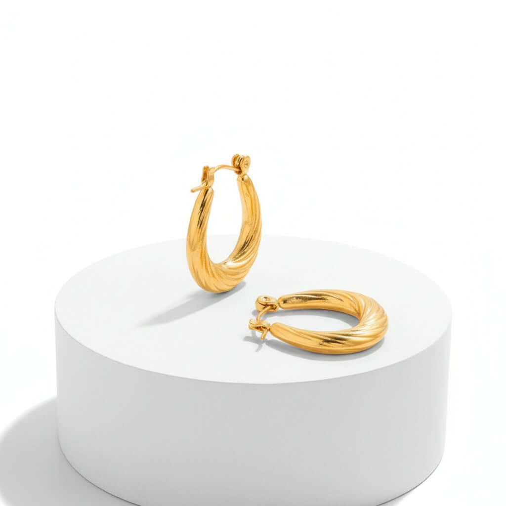 Pair of Twisted U Shaped Gold Hoop Earrings on a white background