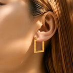 Modern Gold Rectangular Hoop Earrings worn by a person with brown hair.