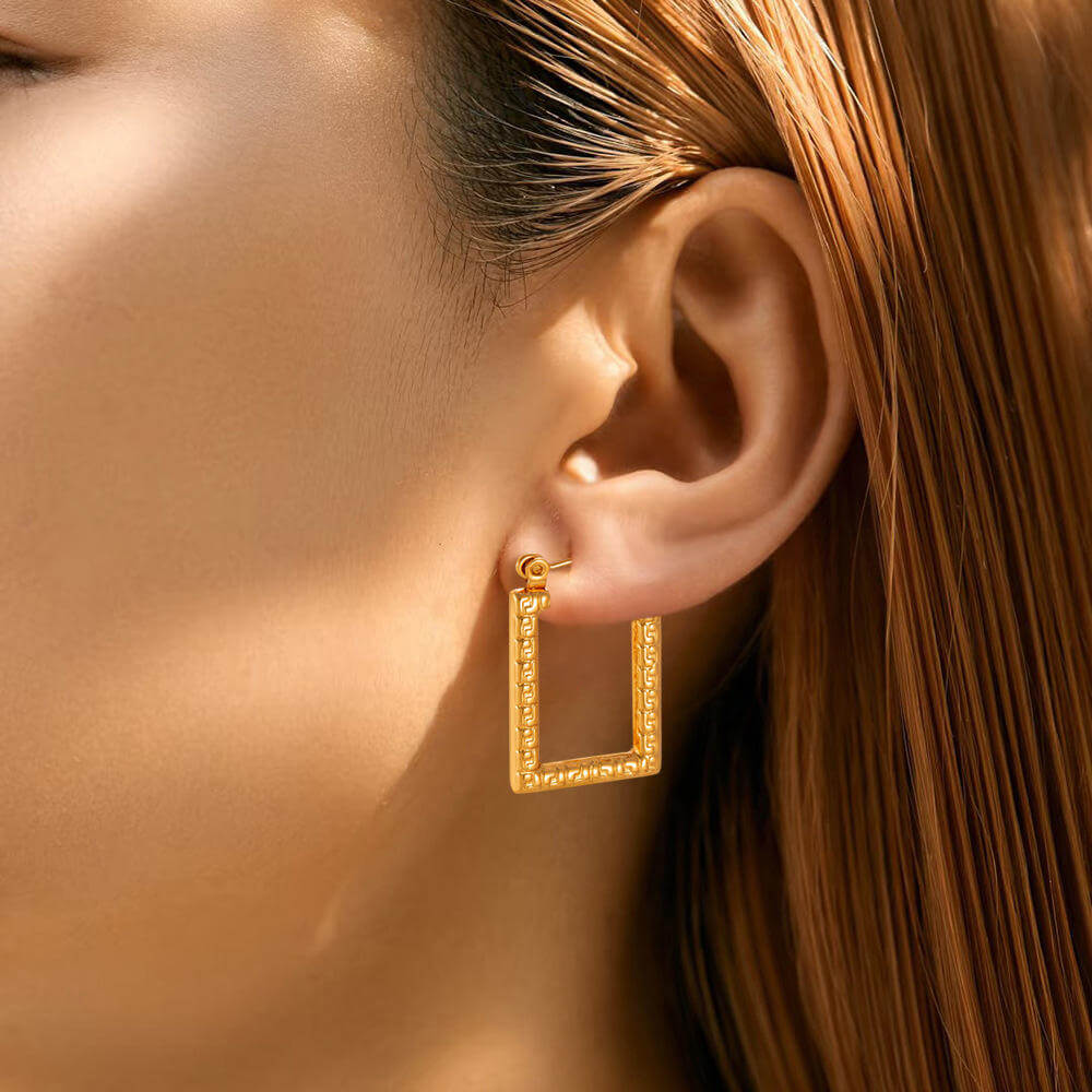 Modern Gold Rectangular Hoop Earrings worn by a person with brown hair.