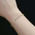 Silver bracelet on a wrist with a lace-trimmed garment in the background