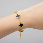 Gold bracelet with black clover charms on wrist, Ceyrah jewelry collection