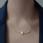 Elegant gold necklace with a single pearl accent on model, Ceyrah jewelry
