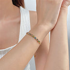 Woman wearing a gold bracelet with colorful gemstones, Ceyrah fashion jewelry