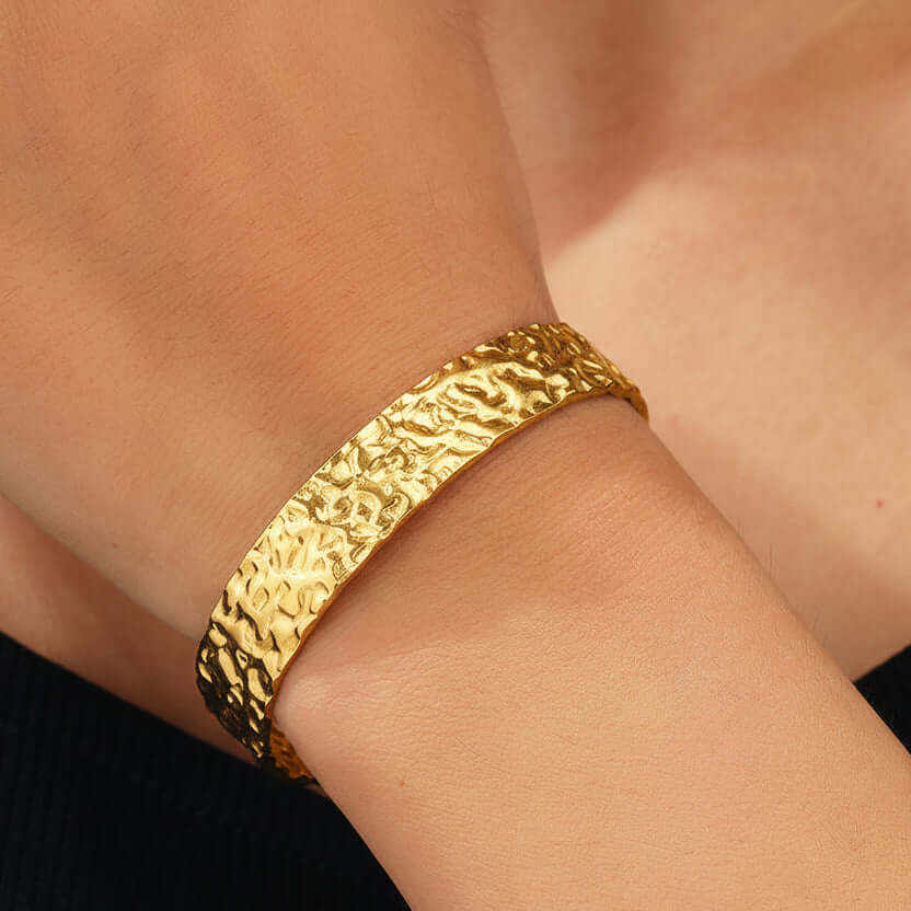 Gold bracelet on a wrist with a close-up view