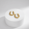 Gold Twisted Rope Hoop Earrings  on a white pedestal