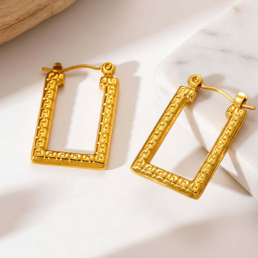 Modern Gold Rectangular Hoop Earrings on a textured stone surface
