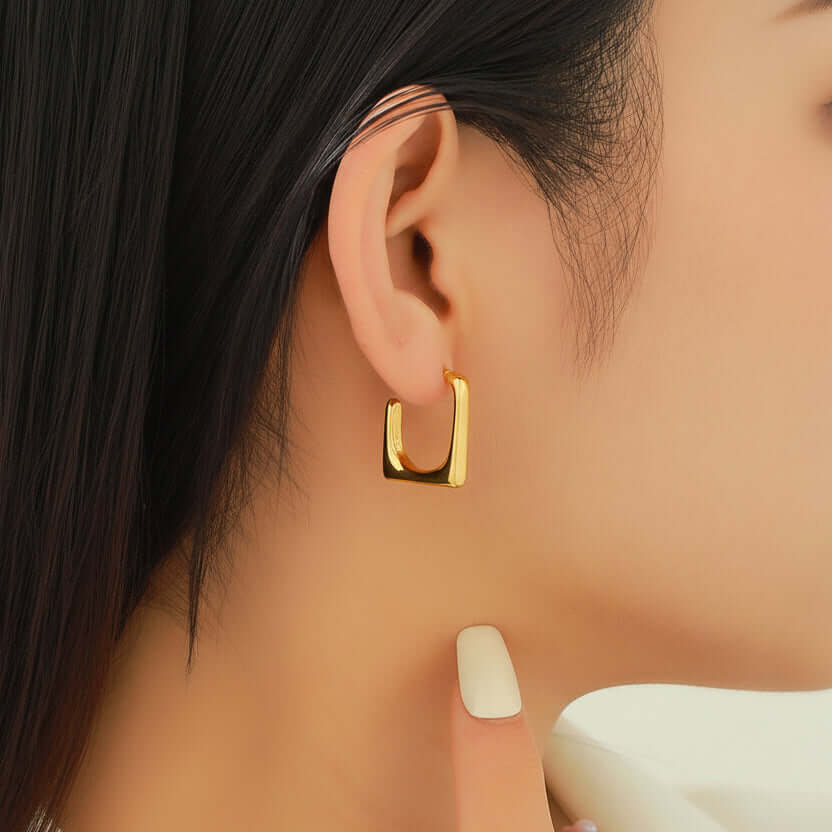 Gold Geometric U-Shaped Stud Earrings worn by a person with dark hair.