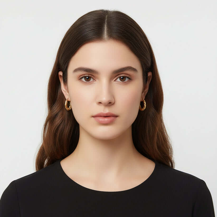 Gold Twisted Rope Hoop Earrings worn by a person 